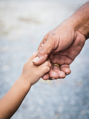 Father holding baby hand finger and color tone effect