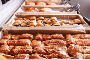 Various Puff pastry, Croissants, buns and pies on shelf in Bakery shop. Pastries and bread in a bakery