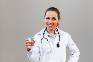 Beautiful female doctor holding glass of water 