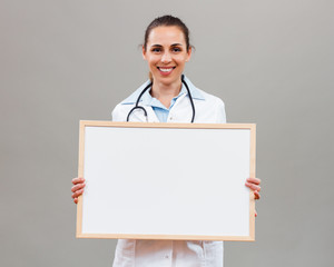 Beautiful female doctor holding whiteboard
