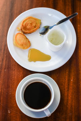 Pancakes with a honey, cream and coffee cup. Top view.
