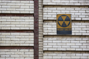 Old cold war fallout shelter sign on brick wall