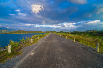 Sunset over dam rural road with mountain