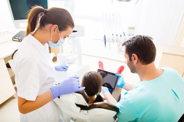 Dentist with a little girl and a Tablet PC.