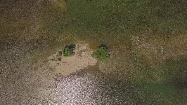 Flight over the river Drina Serbia. Aerial view of river Drina. Footage recorder from drone in full HD resolution.View down the river. Looking down to the water and shoal and trees 