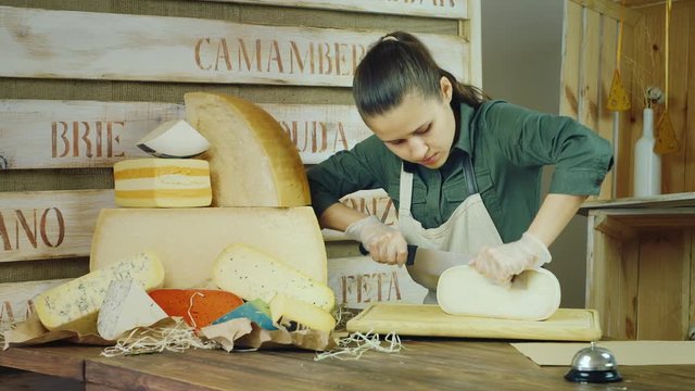 The seller cheese at work - cutting the cheese knife