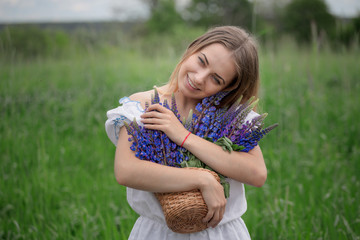 Portrait of beautiful young woman with flowers in the field