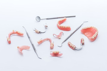 Set of dentures and dental tools on white background