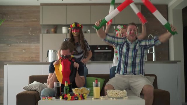 4k footage, two football fan couples watching match at home cheering for italy sorry for germany
