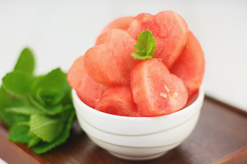 White bowl full of red hearts from the watermelon.