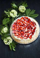 Strawberry and cream tart with powdered sugar and flower decorat