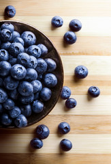 Blueberries group in black jar on wooden cutting board