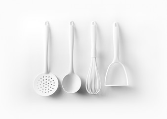 White kitchen tools hanging on white background