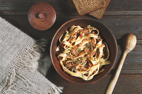 pasta tagliatelle bolognese on the wooden table, rustic style