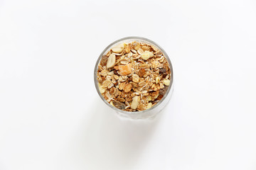 Granolai is for the breakfast in the transparent glass with yogurt, napkins and spoons on white background