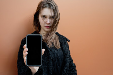 atractive woman with smartphone with black screen- space for tex