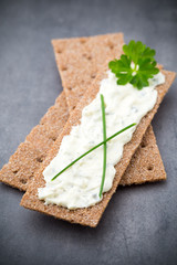 Crispbread with soft cheese with herbs and bacon.
