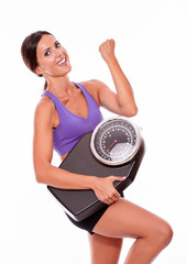 Healthy smiling brunette with a scale