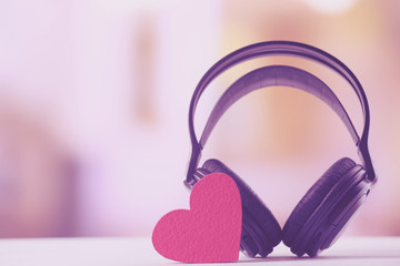 Black headphones with heart on unfocused background