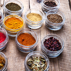 Spices in jars on wooden background. Food