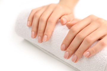 Woman hands with beautiful manicure on white towel