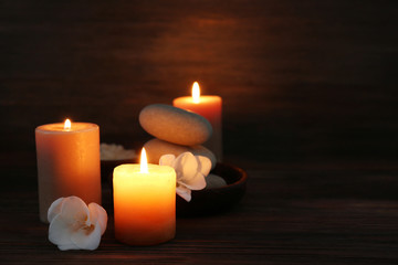 Obraz na płótnie Canvas Spa composition with alight candles on wooden background in the dark