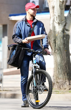 Young Man With Bike Delivering Pizza