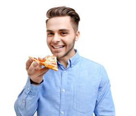 Young handsome man with pizza on light background