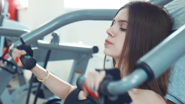Brunette woman doing chest exercise then drinking water
