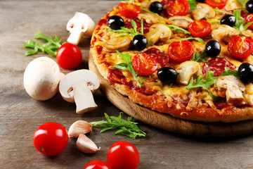 Delicious tasty pizza with ingredients on wooden table