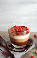 Delicious dessert with rowan in glass on table