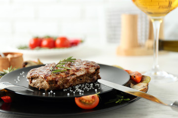 Delicious grilled steak on plate with white wine
