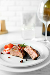 Delicious grilled steak on plate with white wine