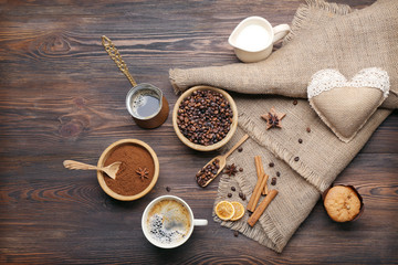 Coffee with beans and spices on wooden table, top view
