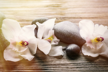 Stones and white orchid on wooden background