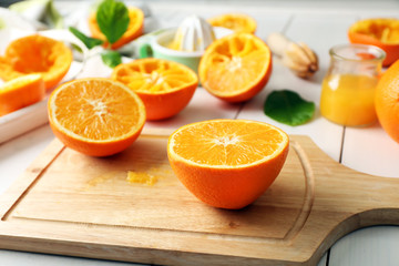 Juicing delicious oranges on white wooden table