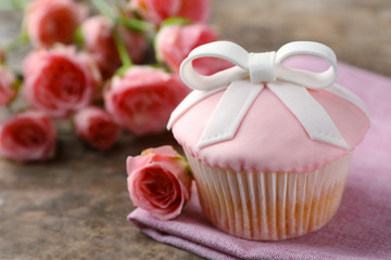 Delicious cake and beautiful roses on table