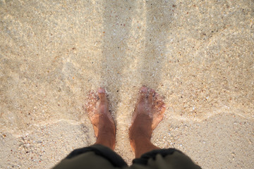 barefoot on clear water beach background