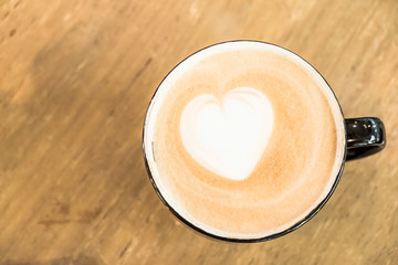 A cup of coffee in a white cup on wooden background