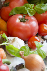 tomato and vegetables on white tablecloth closeup