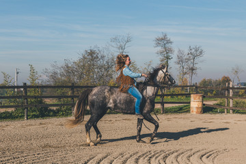 Pretty girl riding her grey horse