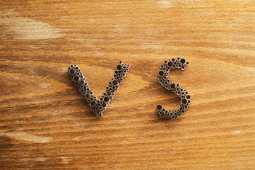 The concept of choice. Letters VS on wooden background