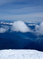 Fototapeta na wymiar Mountains, Snow, Sky and Clouds. Breathtaking view from Mount Baker summit, North Cascades National Park, Washington State, USA. 