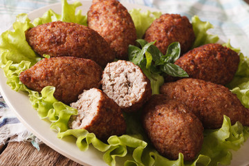 Delicious spicy Kubbeh with bulgur, onion and pine nuts macro. horizontal
