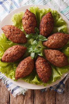 Arabic Kubbeh tasty meatballs close up on a plate. Vertical top view
