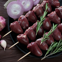Close-up of uncooked kabobs with turkey hearts, above view