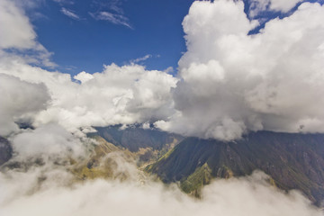 Fototapeta na wymiar huge white clouds above green mountains