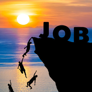 Silhouette of people climbs into cliff to reach the word JOB with sunrise (find job recruitment concept)