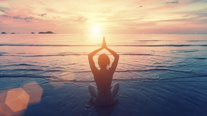 Crédence de cuisine en verre imprimé École de yoga Silhouette jeune femme pratiquant le yoga sur la plage au coucher du soleil. Tranquillité et concentration.