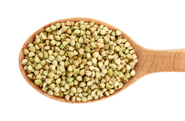 Wooden spoon with green buckwheat isolated on white background.